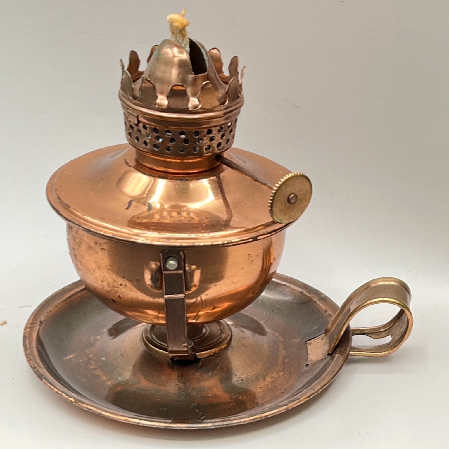 A vintage copper miniature chamber oil lamp featuring a round dish saucer base with a finger loop handle and a crown burner gallery with cotton wick. - Photo 5
