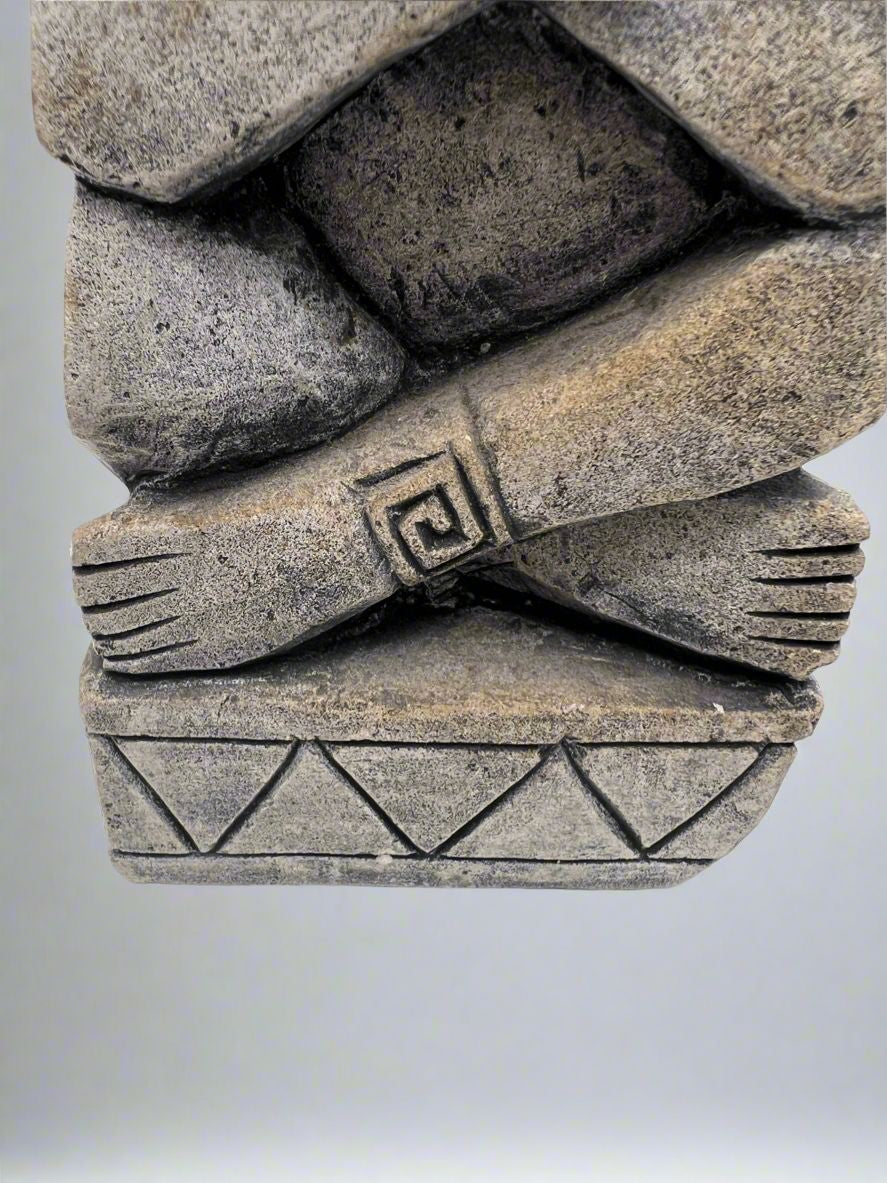 A carved gray stone bookend depicting a seated Aztec or Mesoamerican figure wearing a feathered headdress with incised geometric patterns on the base. - Photo 4