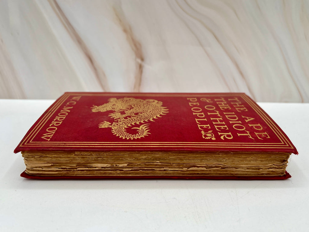 Antique red cloth hardcover book titled The Ape, the Idiot & Other People by W. C. Morrow, featuring an ornate gilt-stamped mythical dragon and gold lettering. - Photo 2