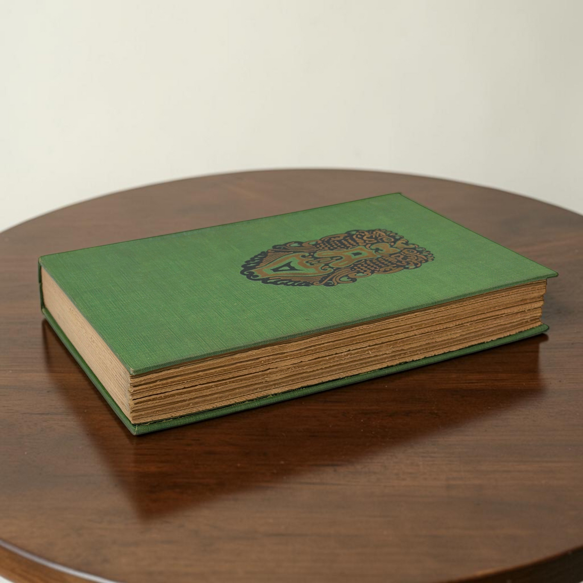Front cover of the 1928 hardcover edition of Vathek bound in textured green book cloth, resting upright on a dark natural wood surface. - Photo 2