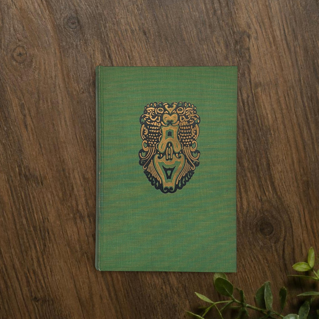 Front cover of the 1928 hardcover edition of Vathek bound in textured green book cloth, resting upright on a dark natural wood surface. - Photo 3