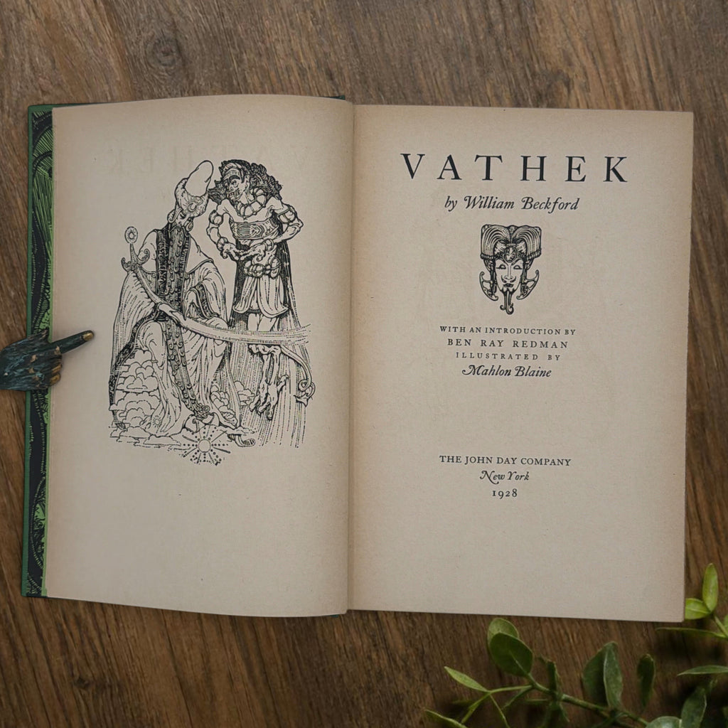 Front cover of the 1928 hardcover edition of Vathek bound in textured green book cloth, resting upright on a dark natural wood surface. - Photo 7