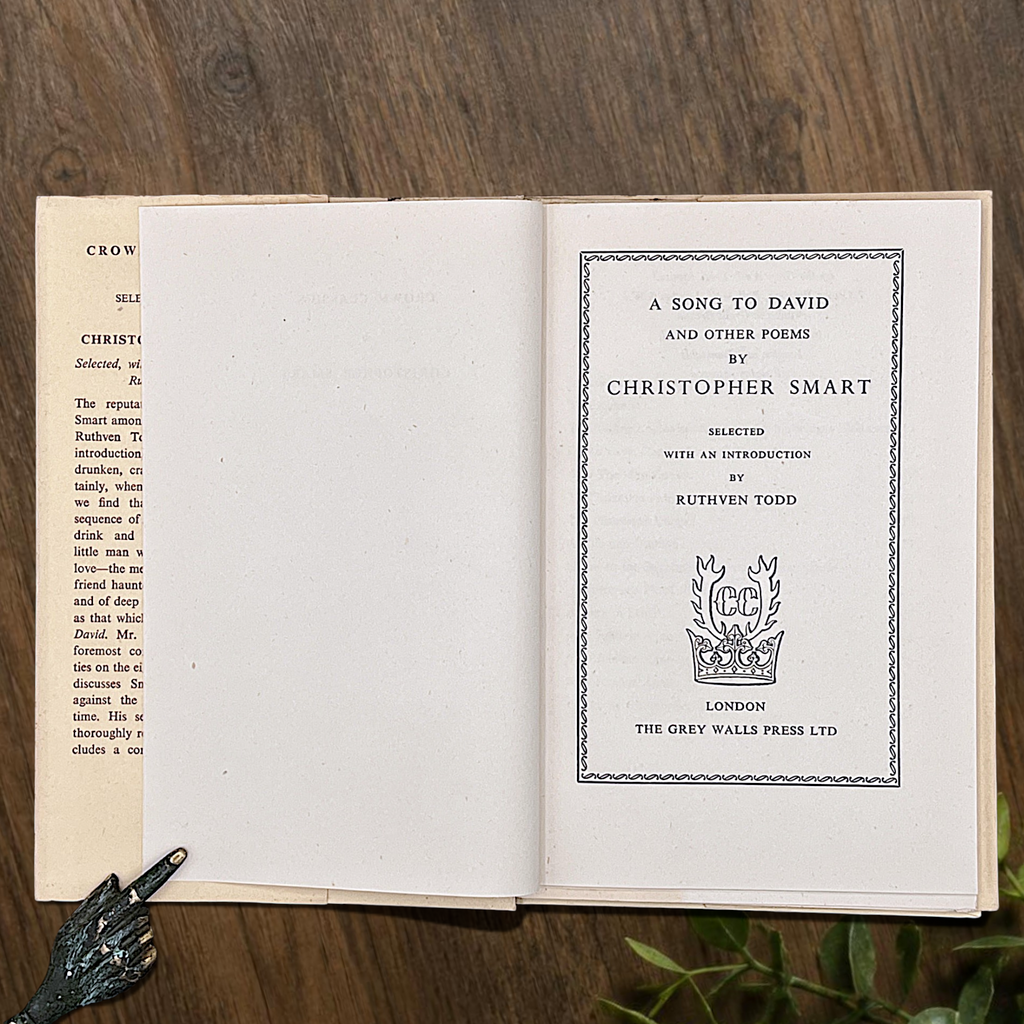An open vintage Crown Classics edition of Christopher Smart's poem A Song to David, showing printed stanzas across cream paper pages on a rustic wooden table. - Photo 3