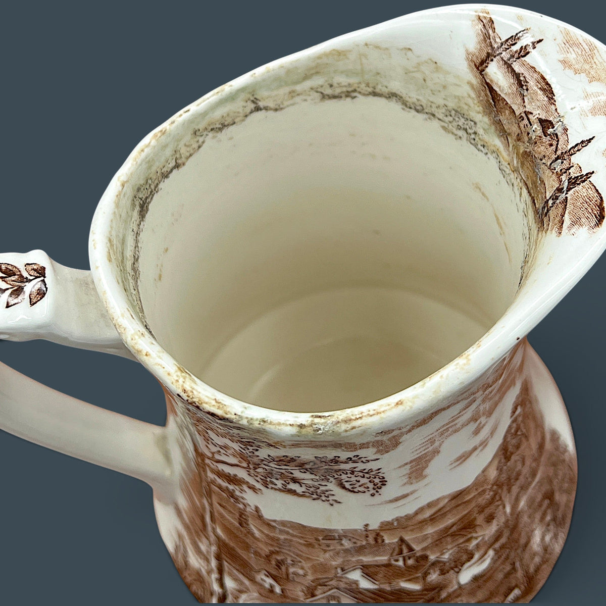 An antique Alfred Meakin brown transferware ceramic pitcher decorated with a detailed countryside landscape and leafy handle motif. - Photo 12