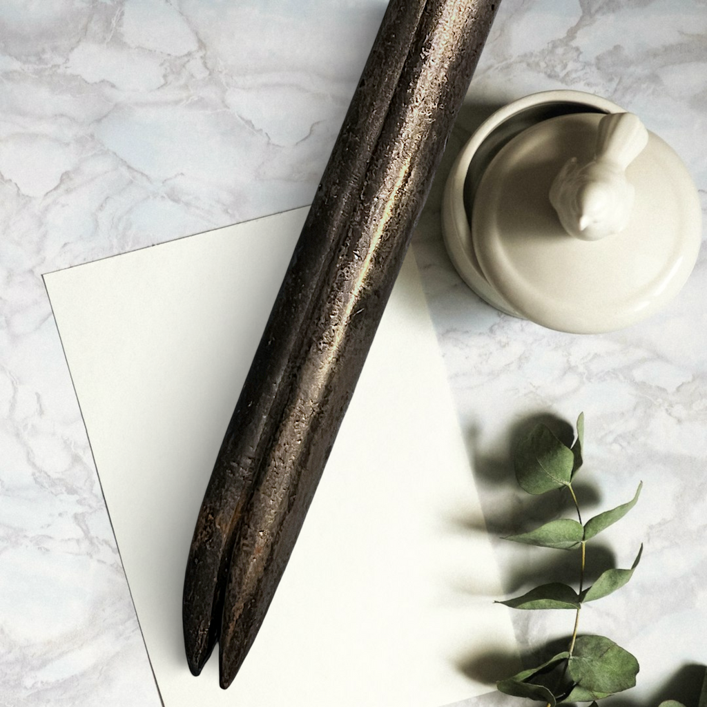 Two antique forged steel Marcel curling iron tongs with tapered points resting diagonally on white paper beside a dried eucalyptus branch. - Photo 6