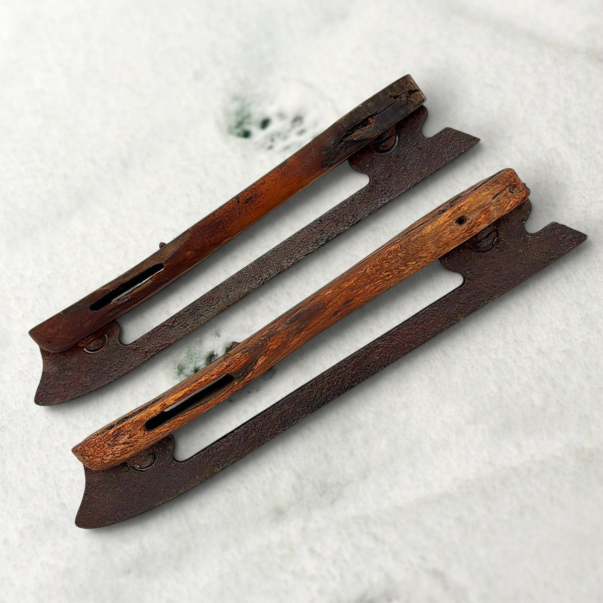 Pair of antique 19th-century hand-carved wood and wrought iron ice skates crossed on snow. - Photo 2