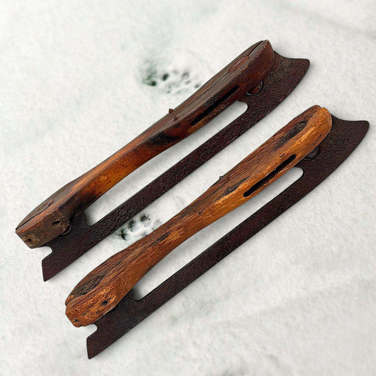Pair of antique 19th-century hand-carved wood and wrought iron ice skates crossed on snow. - Photo 4