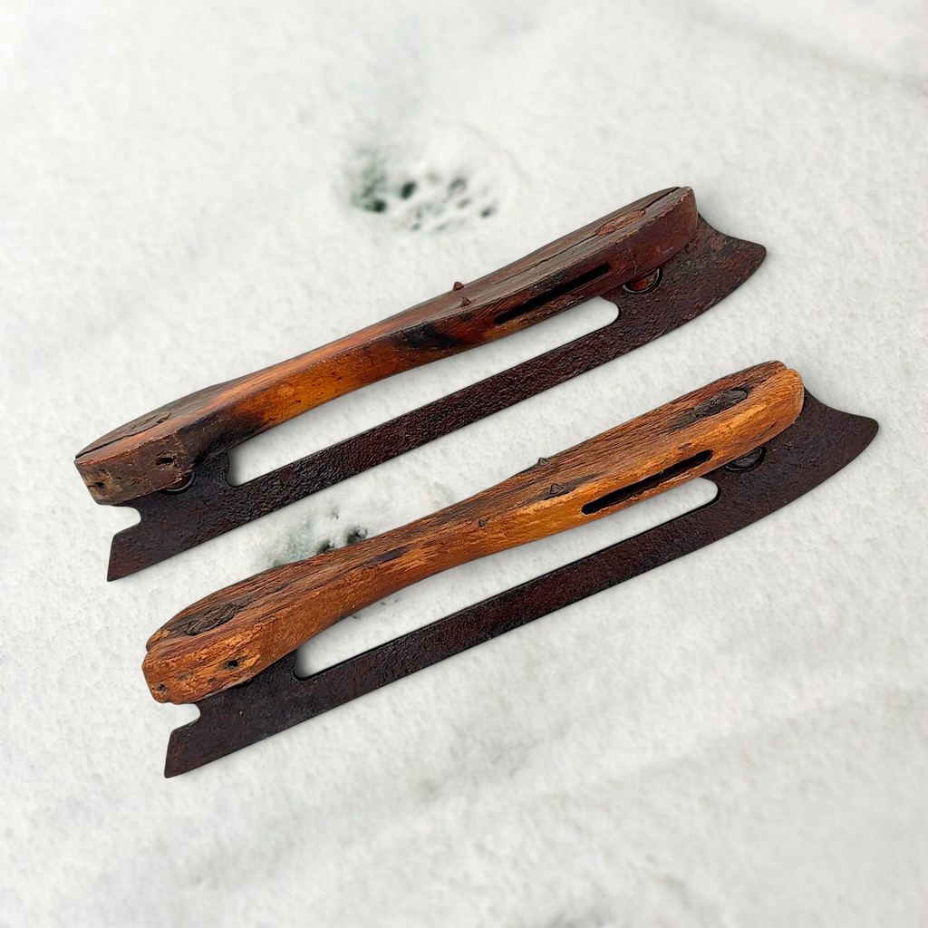 Pair of antique 19th-century hand-carved wood and wrought iron ice skates crossed on snow. - Photo 5