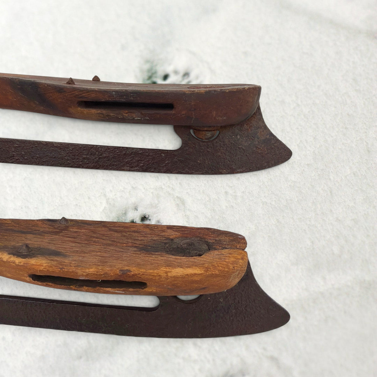 Pair of antique 19th-century hand-carved wood and wrought iron ice skates crossed on snow. - Photo 7