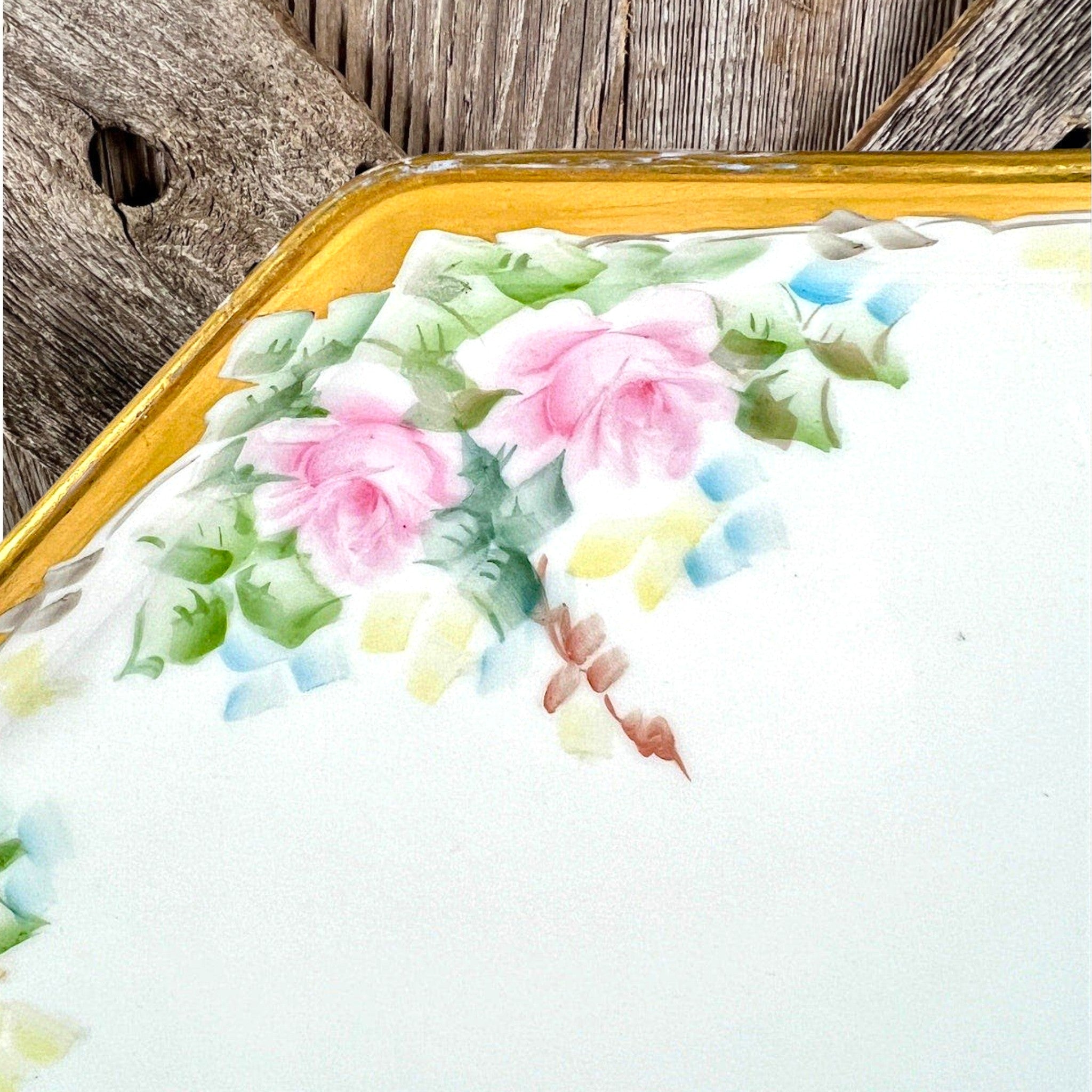 An antique white porcelain octagonal serving platter featuring a delicate gold-gilded rim, presented on a display stand among green foliage. - Photo 2