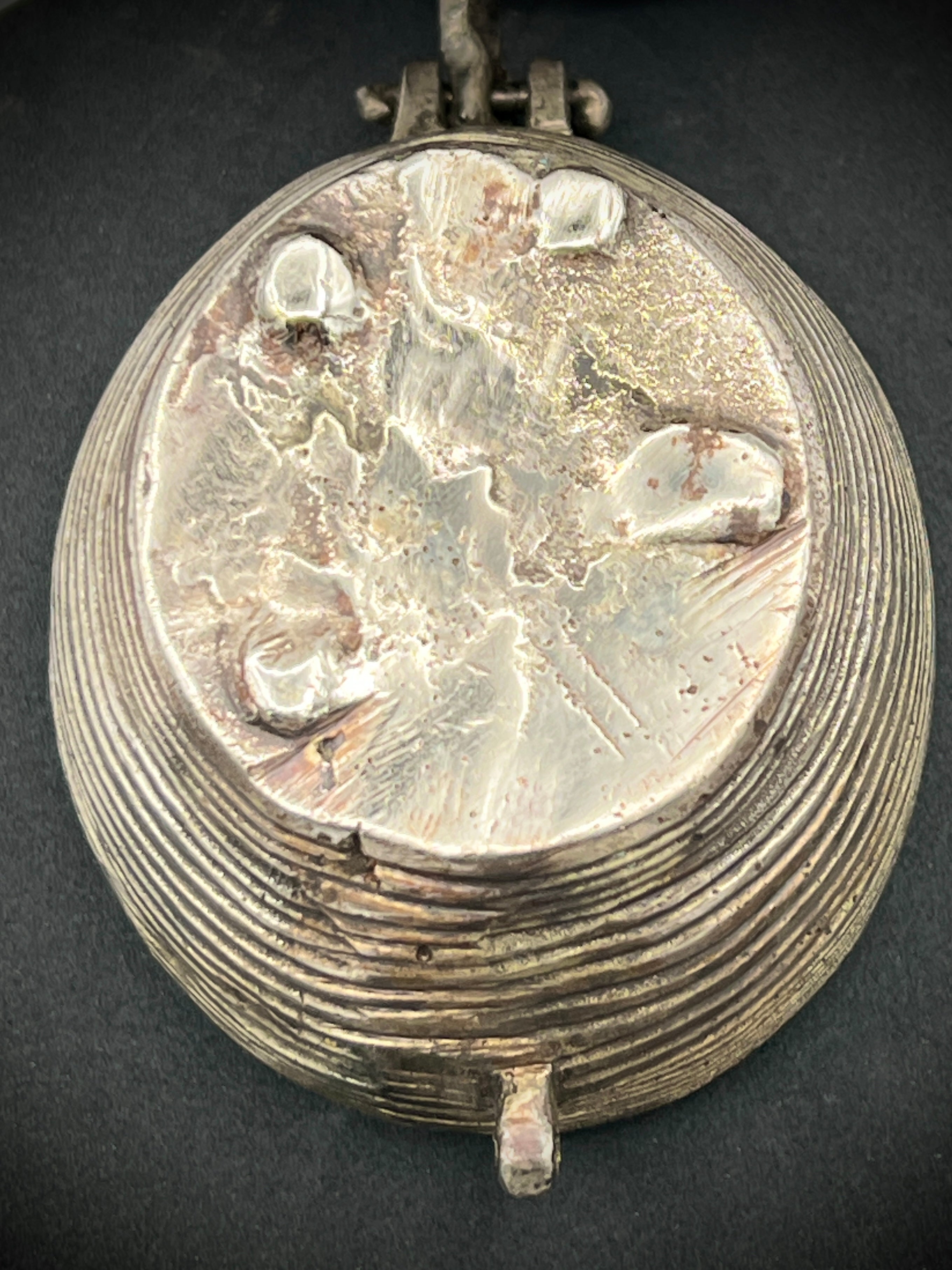 Antique silver-toned, horn-shaped metal vessel shown from a top-down angle with its hinged lid open, revealing a heavily patinated interior with hints of verdigris oxidation. - Photo 5