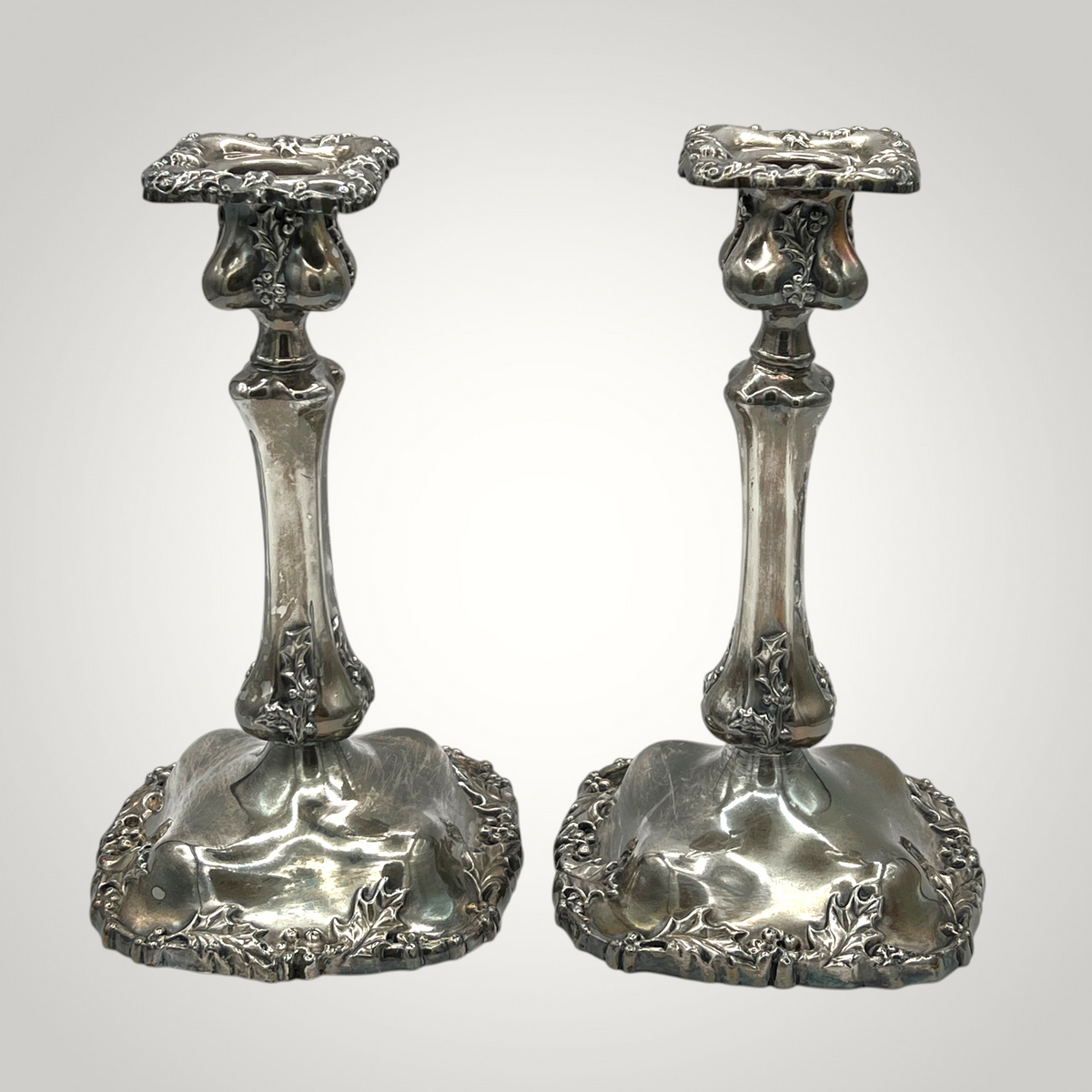 Pair of antique Victorian quadruple silverplate candlesticks with embossed holly leaf and berry relief borders on square contoured bases and fluted stems. - Photo 2