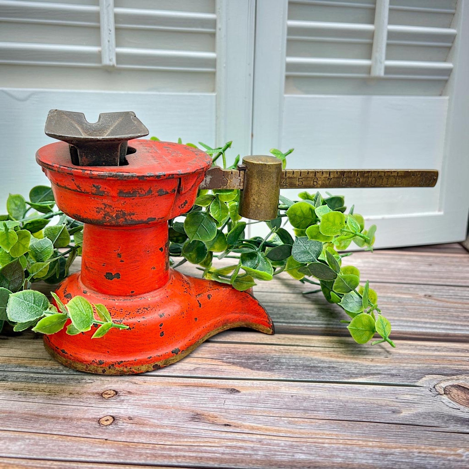 An antique Howe Scale Co. counterbalance scale with a red painted cast iron base and a graduated brass beam holding a solid cylindrical brass slider weight. - Photo 1