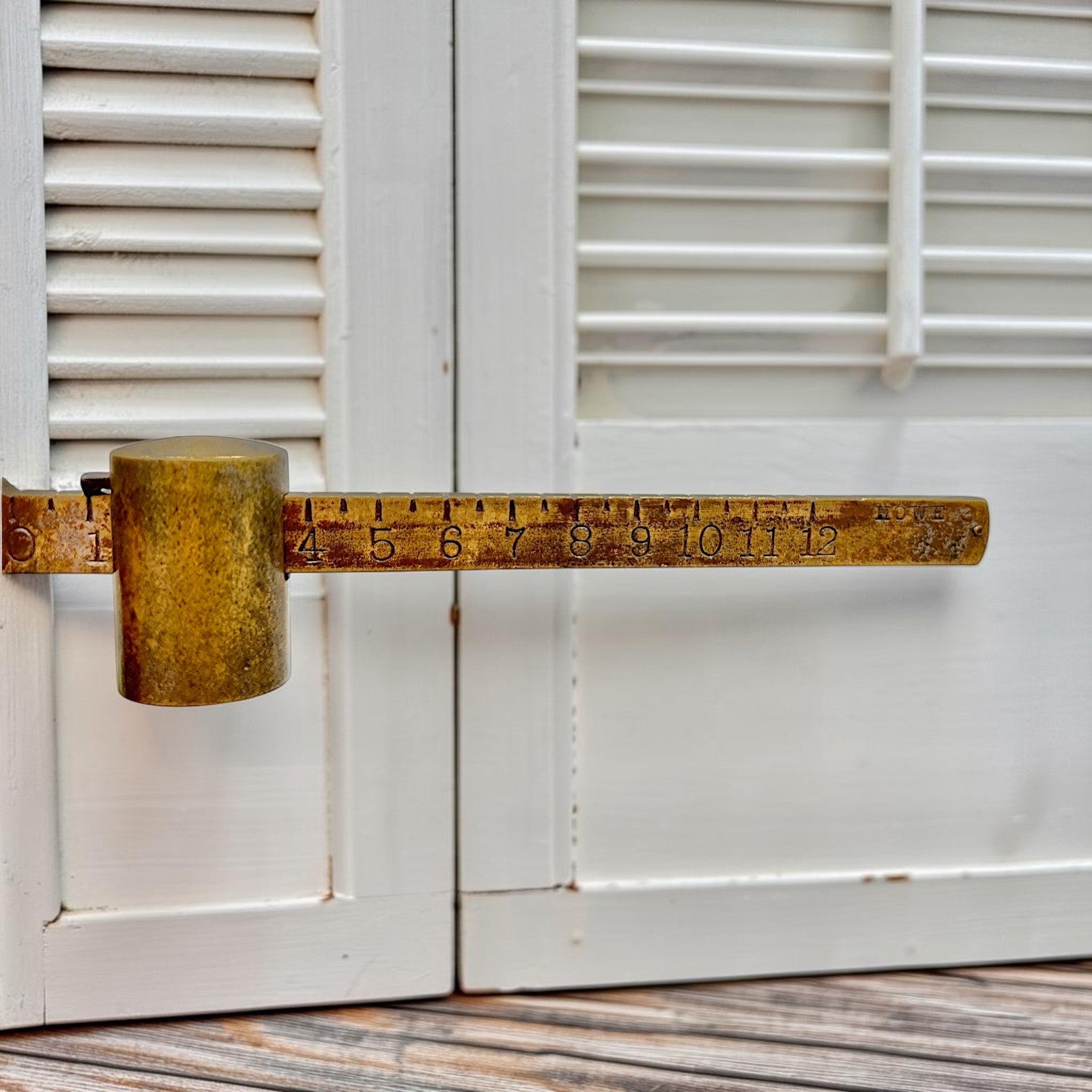 An antique Howe Scale Co. counterbalance scale with a red painted cast iron base and a graduated brass beam holding a solid cylindrical brass slider weight. - Photo 4