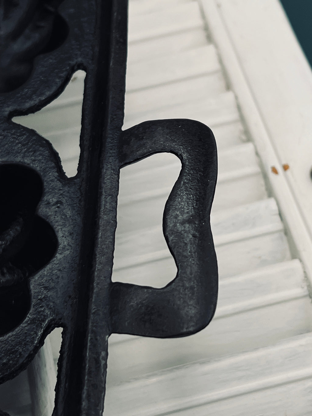 A black antique cast iron 12-cup gem pan with deeply fluted scalloped molds in a 4-4-4 open-frame layout and wavy stylized handles at both ends. - Photo 3