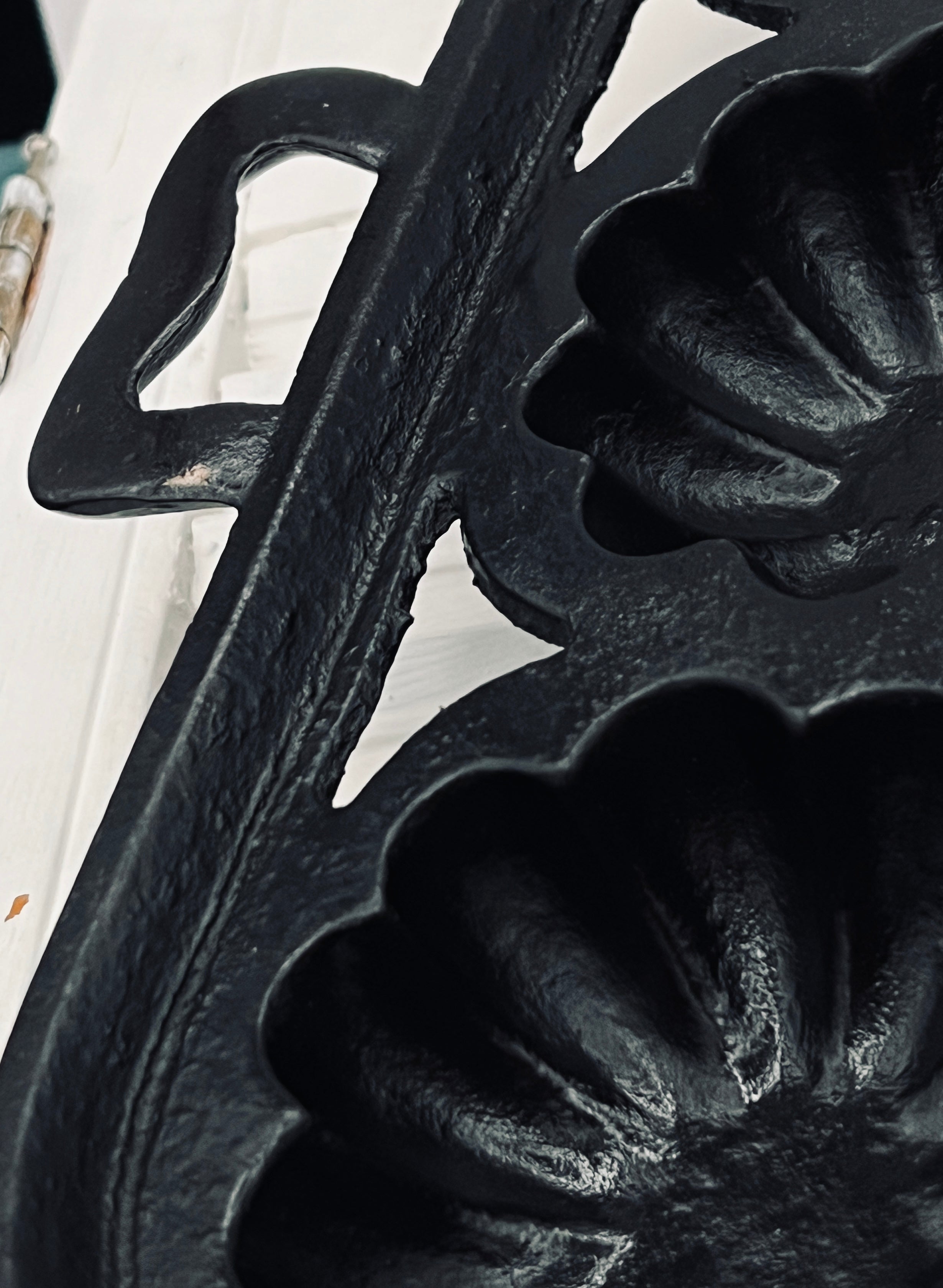 A black antique cast iron 12-cup gem pan with deeply fluted scalloped molds in a 4-4-4 open-frame layout and wavy stylized handles at both ends. - Photo 4