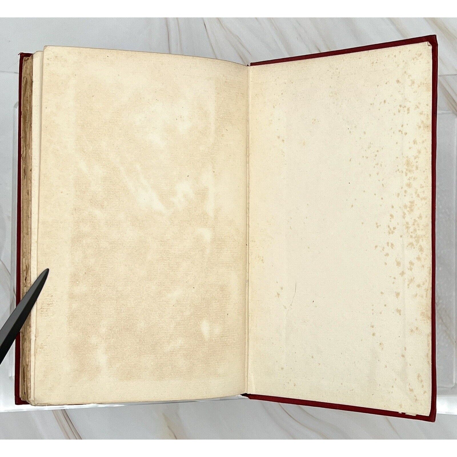 Open first edition hardcover book with blank aged pages, red binding, rare 1897 printing.