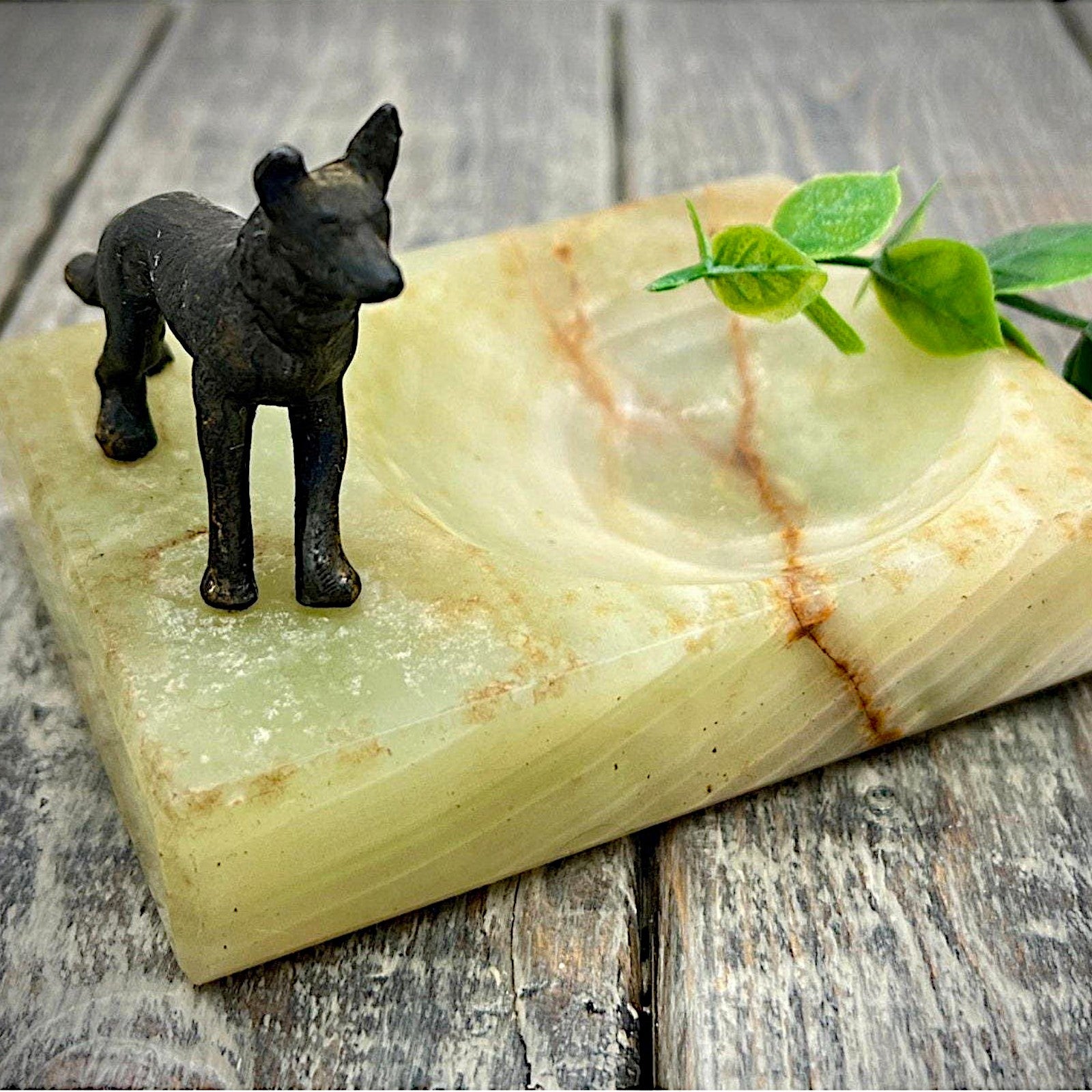 An Art Deco green onyx trinket dish featuring a detailed dark patinated metal figurine of a standing German Shepherd dog mounted on the corner of the polished translucent green stone base. - Photo 1