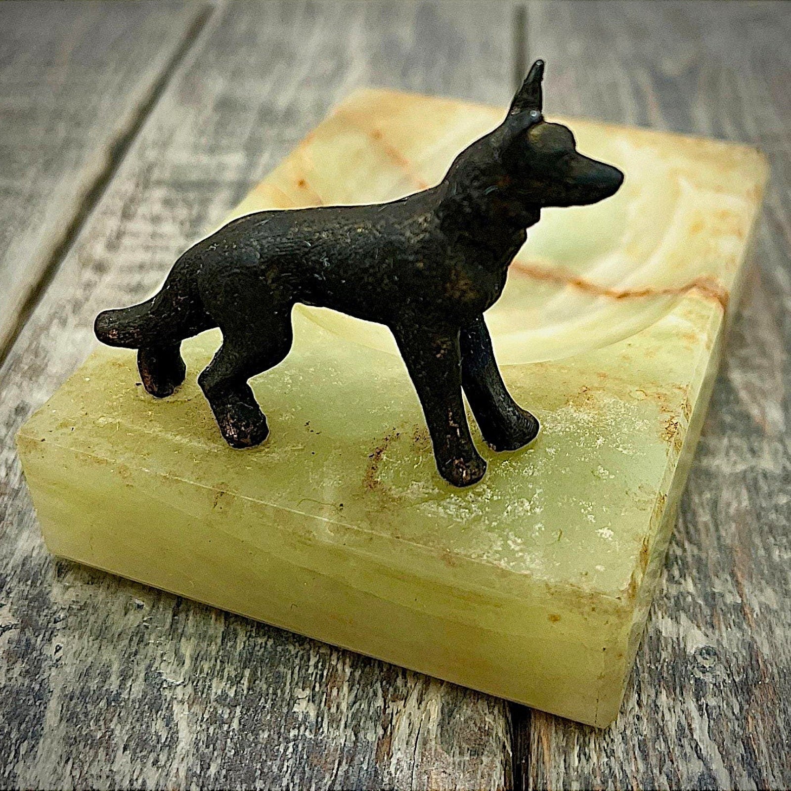 An Art Deco green onyx trinket dish featuring a detailed dark patinated metal figurine of a standing German Shepherd dog mounted on the corner of the polished translucent green stone base. - Photo 2