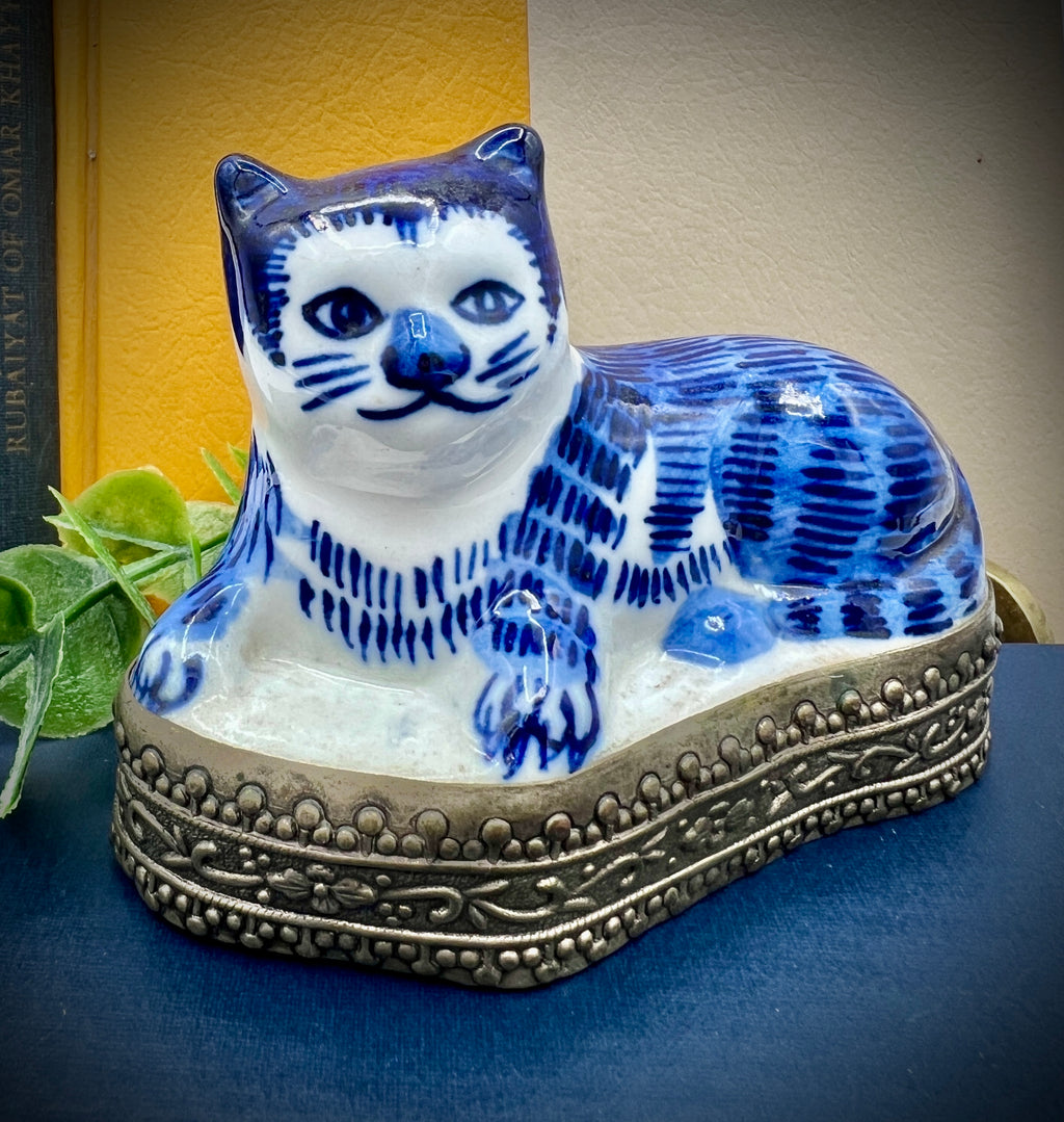 A vintage blue and white glazed porcelain cat figurine with cobalt blue painted patterns resting on an ornate embossed metal gallery base. - Photo 2