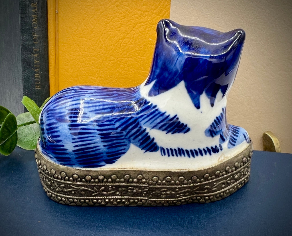 A vintage blue and white glazed porcelain cat figurine with cobalt blue painted patterns resting on an ornate embossed metal gallery base. - Photo 4