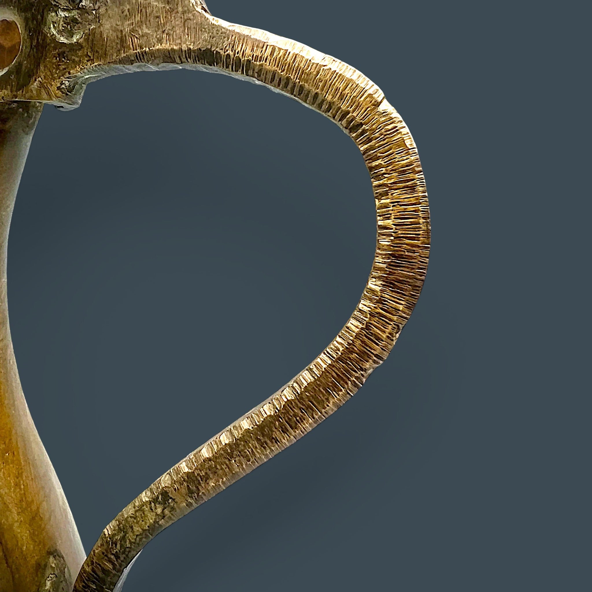 An antique hand-forged brass pitcher with a tapered neck and warm golden-brown patina, displayed against a dark background. - Photo 5