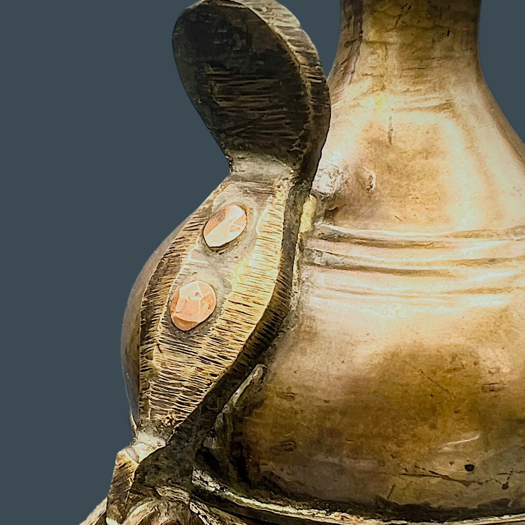 An antique hand-forged brass pitcher with a tapered neck and warm golden-brown patina, displayed against a dark background. - Photo 6