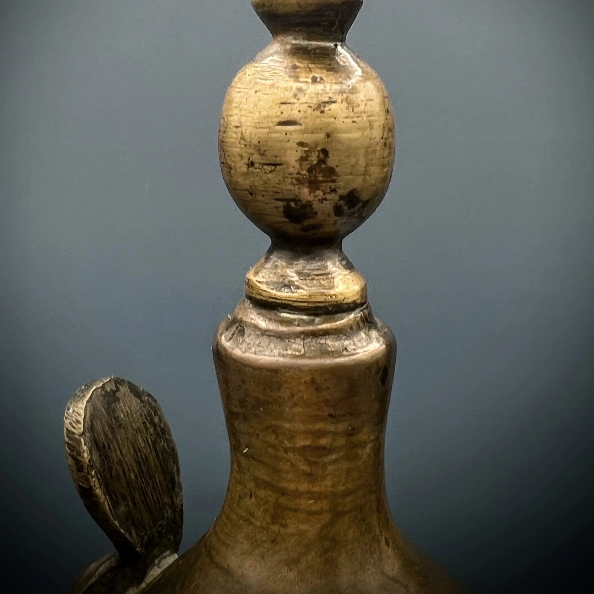 An antique hand-forged brass pitcher with a tapered neck and warm golden-brown patina, displayed against a dark background. - Photo 7