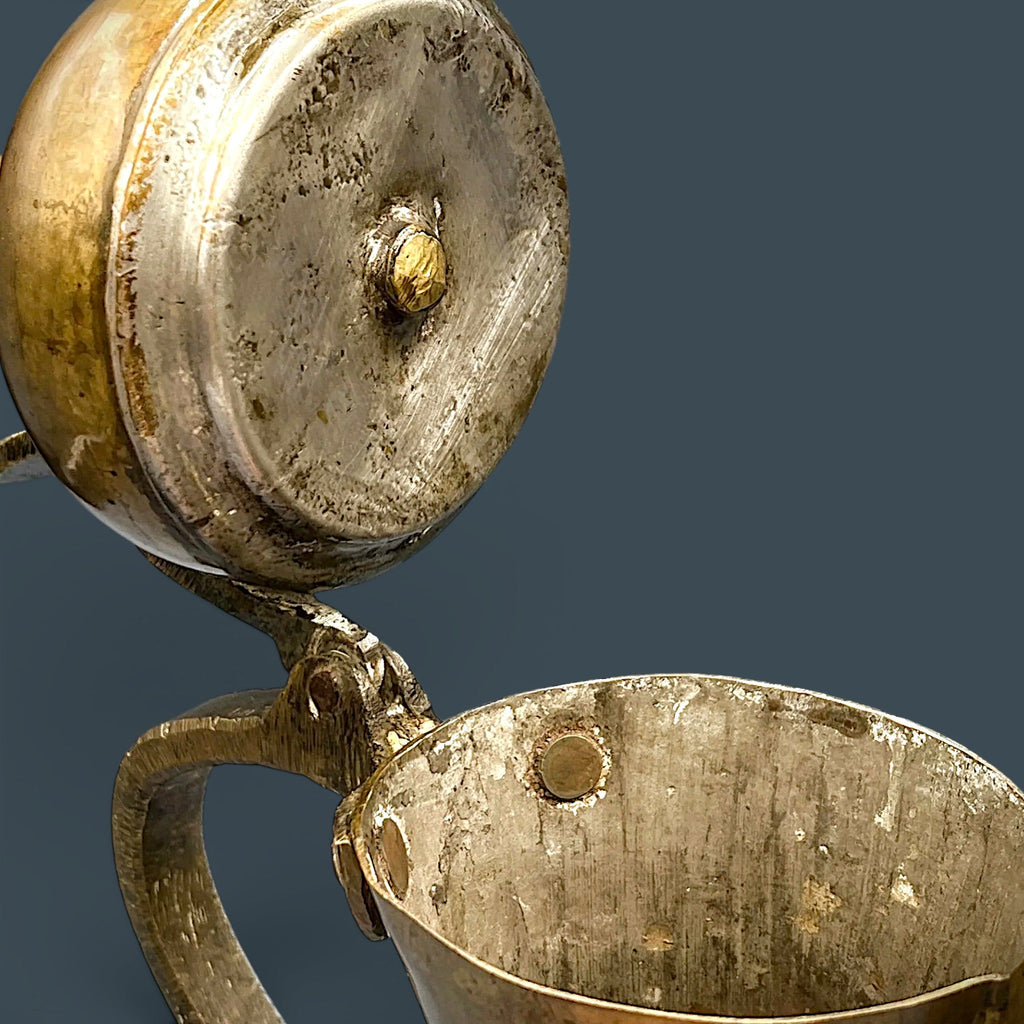 An antique hand-forged brass pitcher with a tapered neck and warm golden-brown patina, displayed against a dark background. - Photo 8