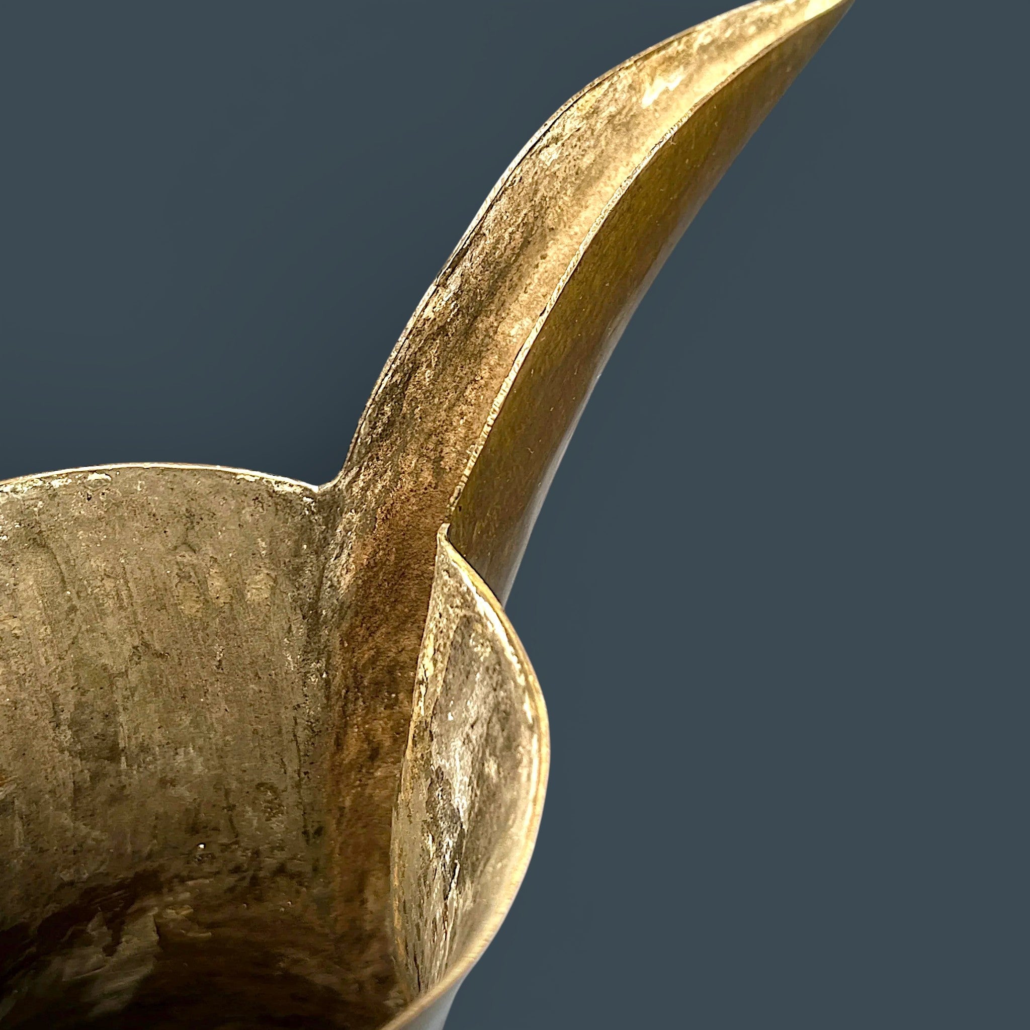 An antique hand-forged brass pitcher with a tapered neck and warm golden-brown patina, displayed against a dark background. - Photo 9