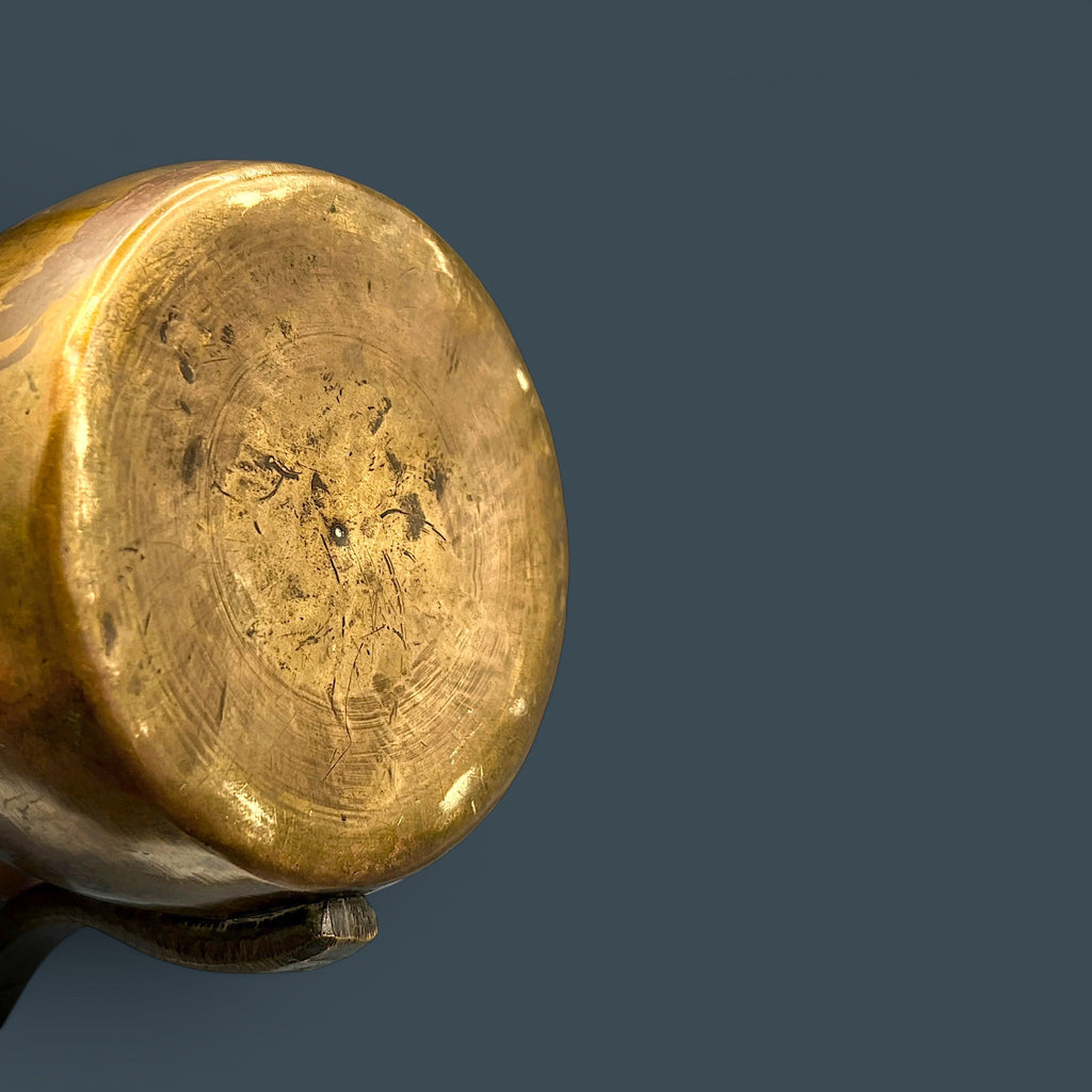 An antique hand-forged brass pitcher with a tapered neck and warm golden-brown patina, displayed against a dark background. - Photo 12