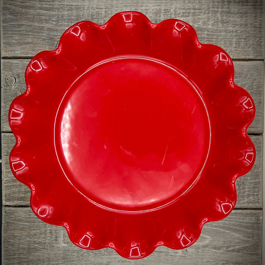 Emile Henry red ceramic deep ruffled pie dish displayed upright on a wooden surface showing its scalloped rim and glossy crimson glaze. - Photo 2