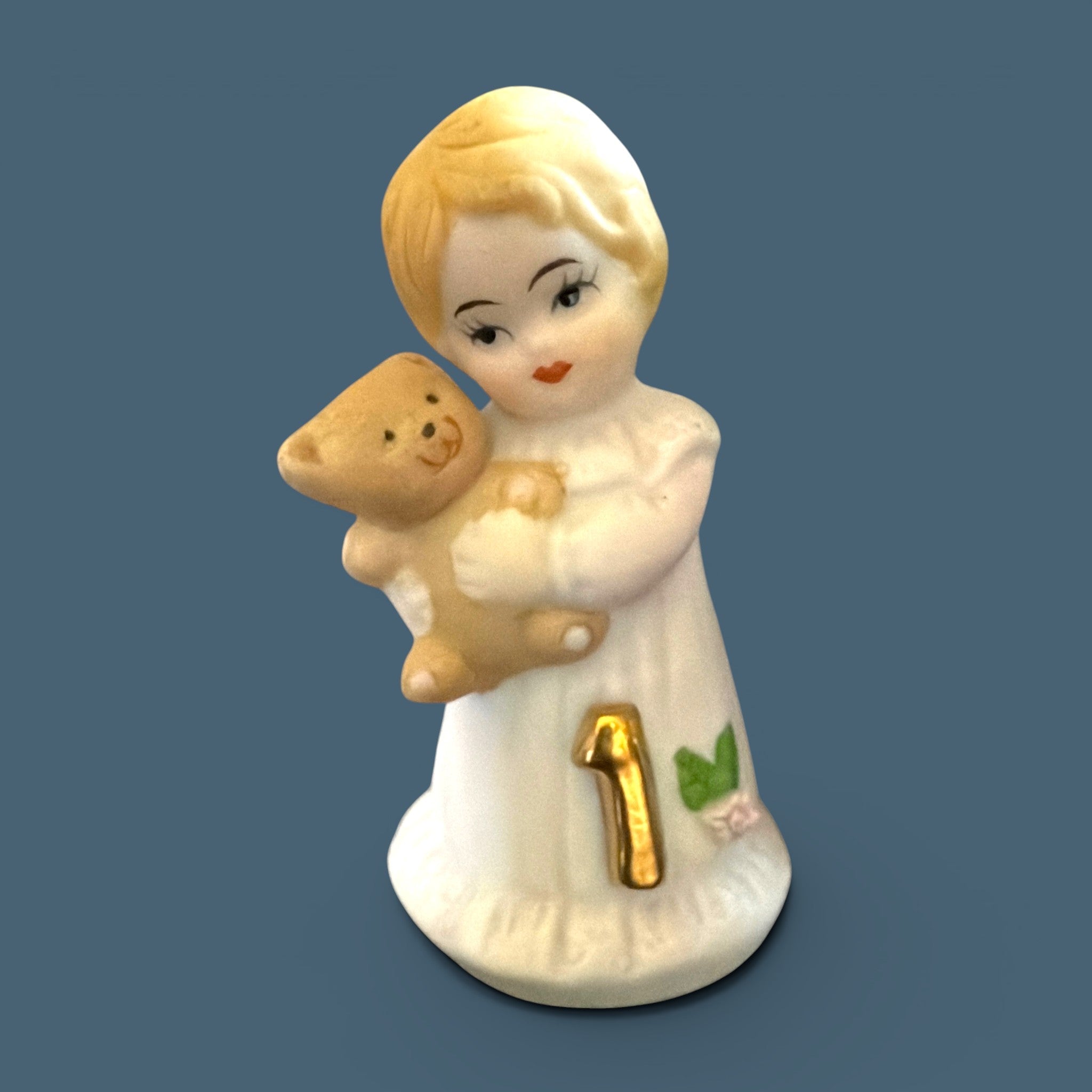 Vintage Enesco Growing Up Girls Age 1 porcelain figurine showing a blonde toddler in a white dress holding a small brown teddy bear with a gold number one on her dress. - Photo 1