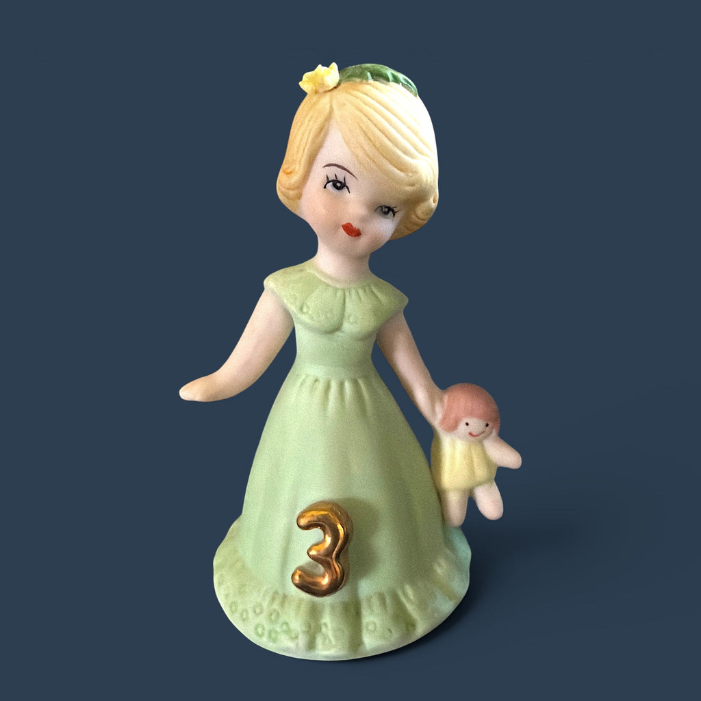 Vintage Enesco Growing Up Girls Age 3 porcelain figurine showing a blonde girl holds her favorite yellow-dressed doll in one hand, while her other hand is elegantly extended. - Photo 1