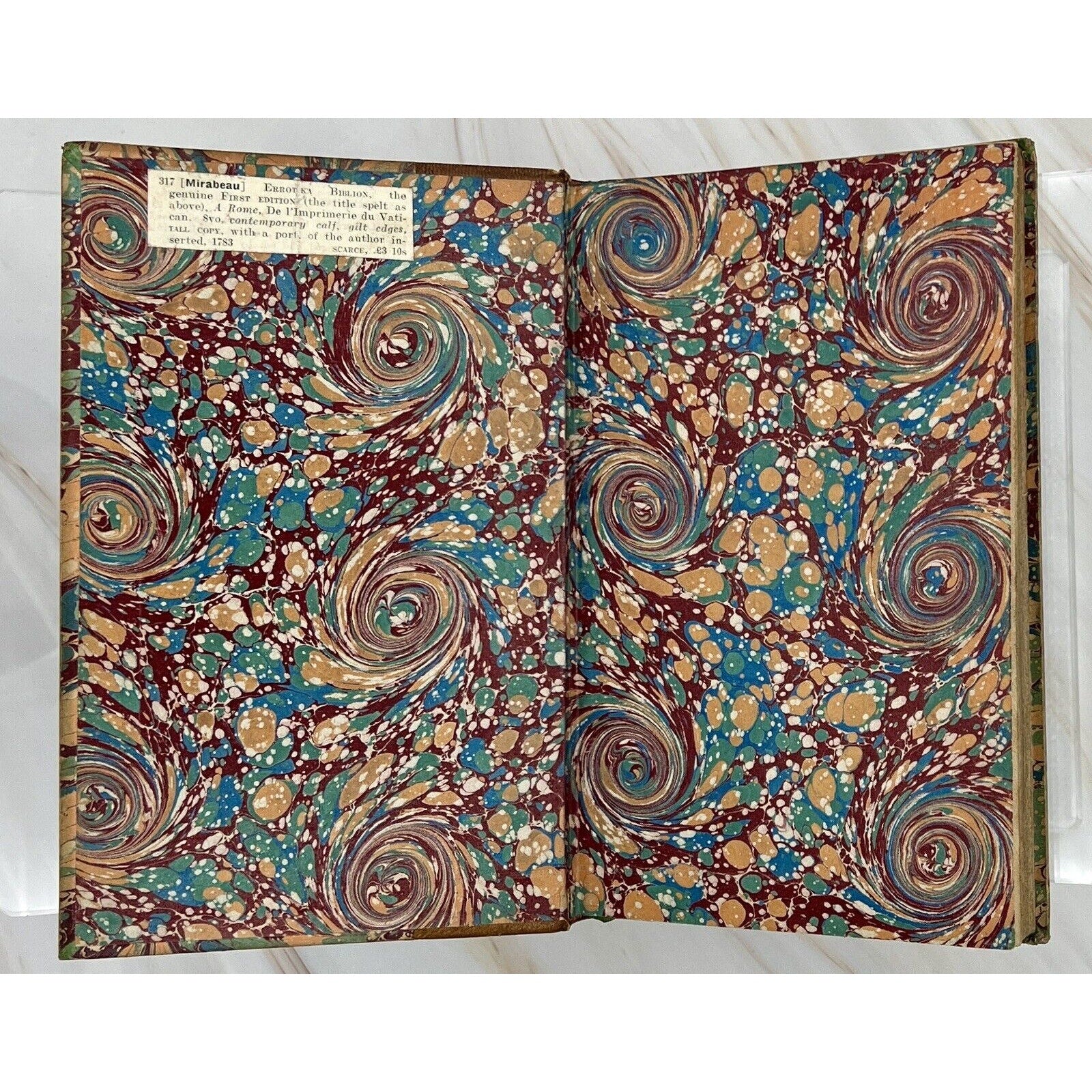 Errotika Biblion de Mirabeau, 1783 first edition, leather-bound book opened to marbled endpapers.