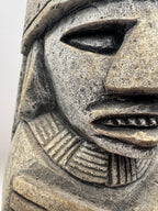 Close-up of a stone sculpture with intricate patterns on a white background