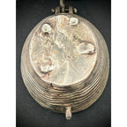 Vintage silver trinket box with engraved design on a dark background