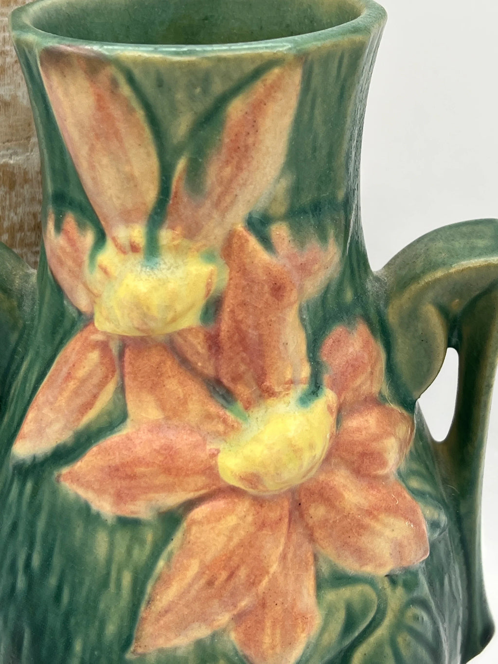 Vintage Roseville Clematis art pottery vase featuring an earthy green textured ground, sculpted angular side handles, and an embossed peach clematis bloom with a yellow center. - Photo 3