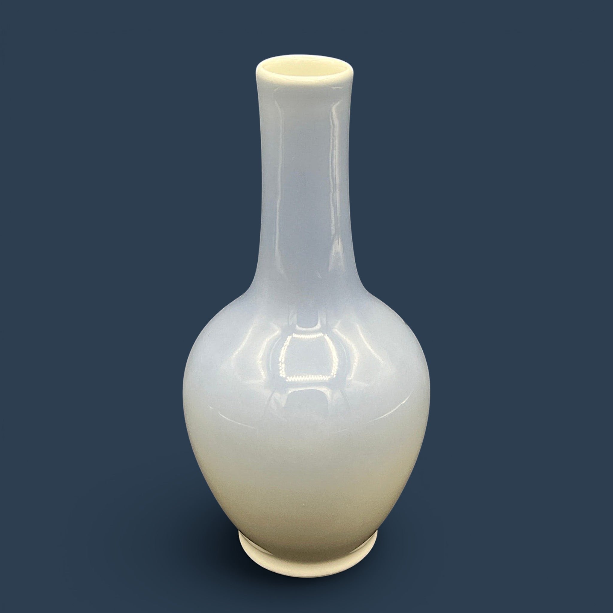 A Royal Copenhagen porcelain bud vase featuring a bulbous body, a slender elongated neck, and a glossy white glaze that fades into a soft cream and pale blue-gray gradient at the base. - Photo 3