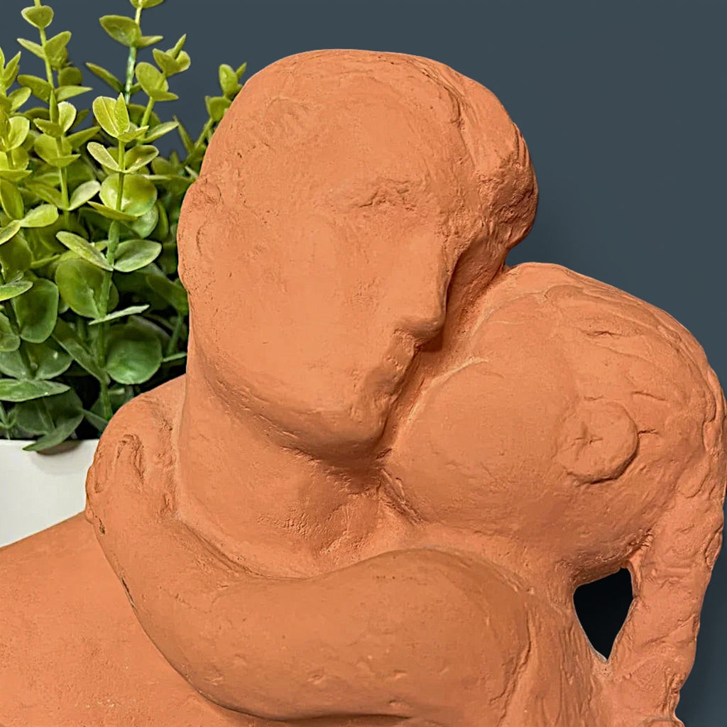 Terracotta clay sculpture depicting two stylized human figures held in a warm close embrace with a hand-modeled rough tactile surface. - Photo 1