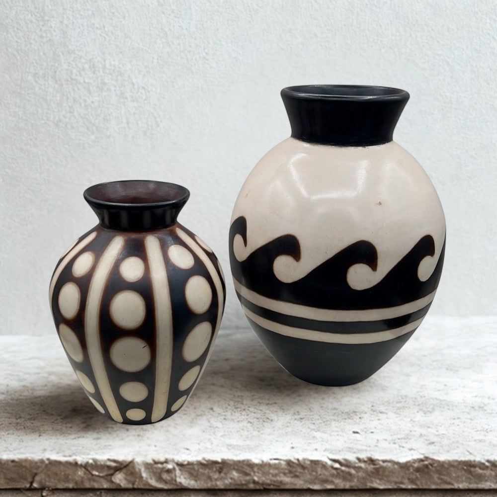 A pair of hand-crafted Chulucanas Peruvian ceramic vases by artist Marcelo Prado, featuring one solid burnished black vase and one patterned cream and black geometric vase. - Photo 1
