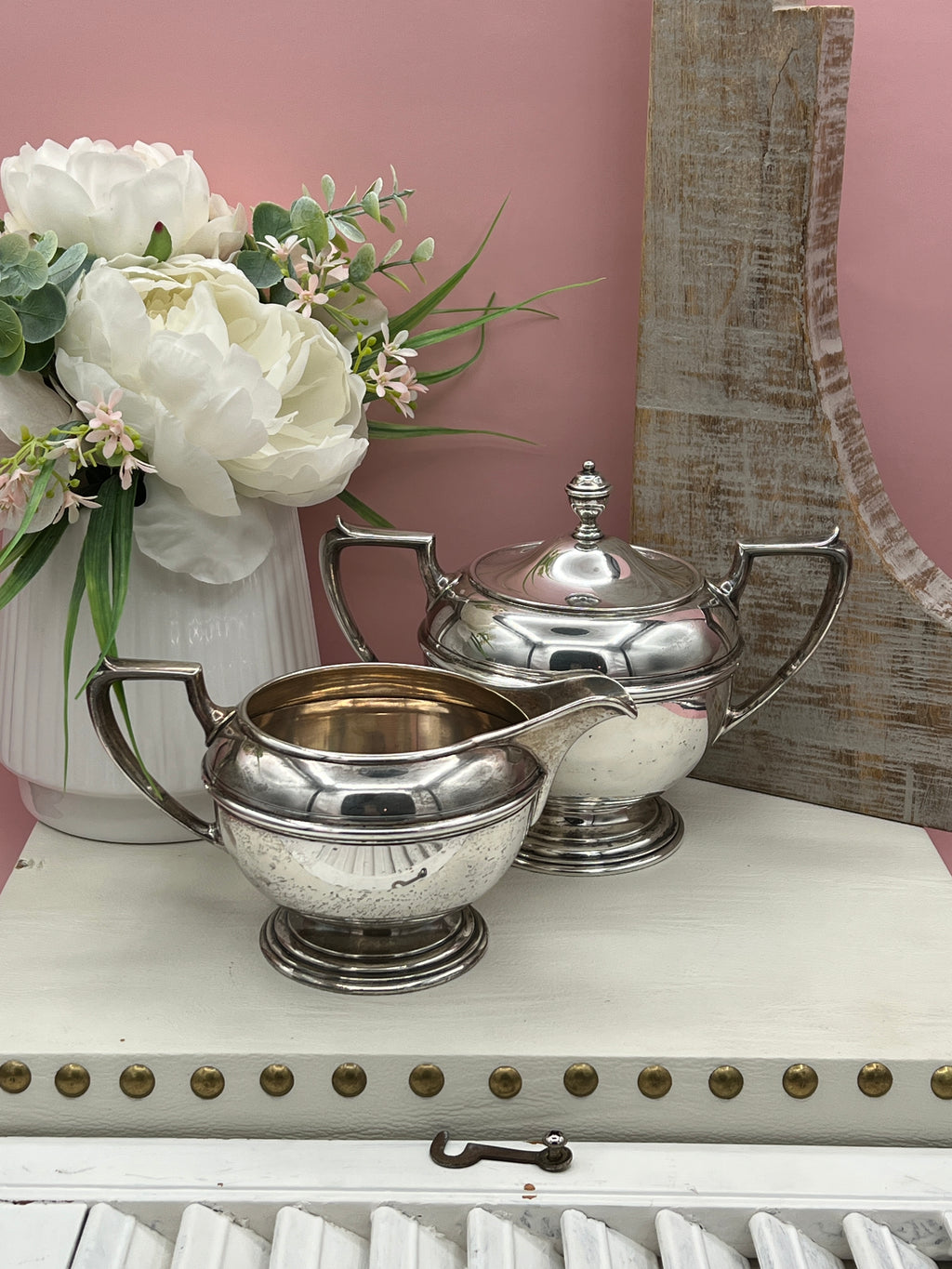 Antique William B. Durgin sterling silver two-handled covered sugar bowl with a polished urn-shaped body, stepped pedestal base, and matching domed lid topped with an urn finial displayed on a white tabletop. - Photo 1