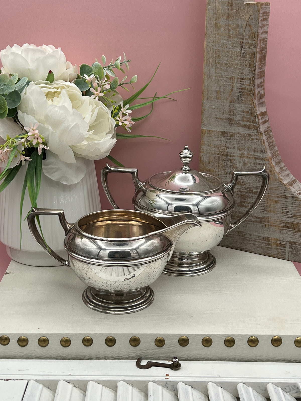 Antique William B. Durgin sterling silver two-handled covered sugar bowl with a polished urn-shaped body, stepped pedestal base, and matching domed lid topped with an urn finial displayed on a white tabletop. - Photo 1