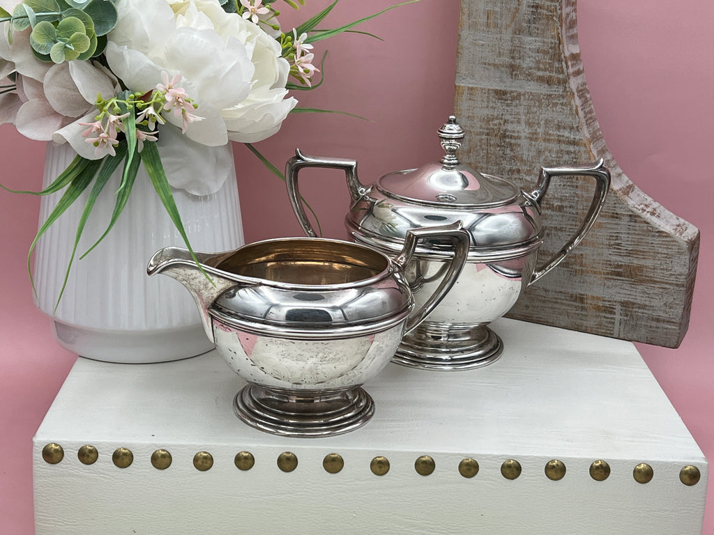 Antique William B. Durgin sterling silver two-handled covered sugar bowl with a polished urn-shaped body, stepped pedestal base, and matching domed lid topped with an urn finial displayed on a white tabletop. - Photo 2