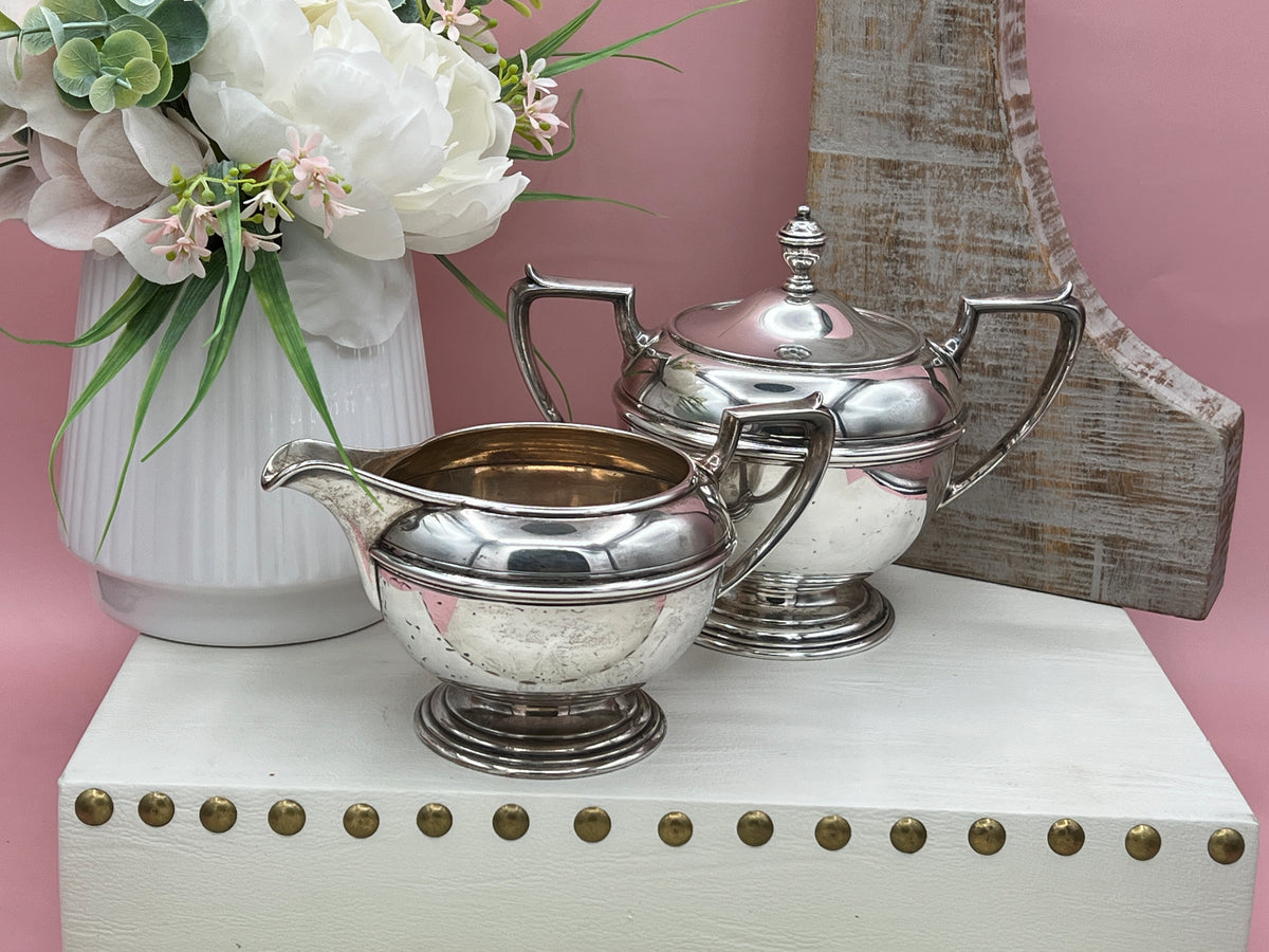 Antique William B. Durgin sterling silver two-handled covered sugar bowl with a polished urn-shaped body, stepped pedestal base, and matching domed lid topped with an urn finial displayed on a white tabletop. - Photo 2