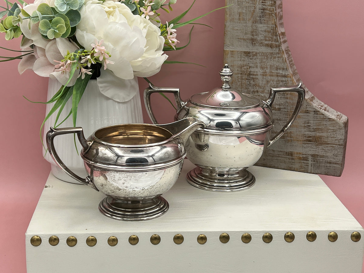 Antique William B. Durgin sterling silver two-handled covered sugar bowl with a polished urn-shaped body, stepped pedestal base, and matching domed lid topped with an urn finial displayed on a white tabletop. - Photo 3