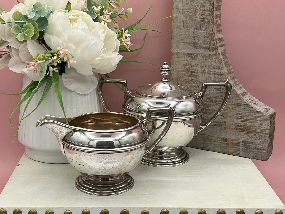 Antique William B. Durgin sterling silver two-handled covered sugar bowl with a polished urn-shaped body, stepped pedestal base, and matching domed lid topped with an urn finial displayed on a white tabletop. - Photo 4