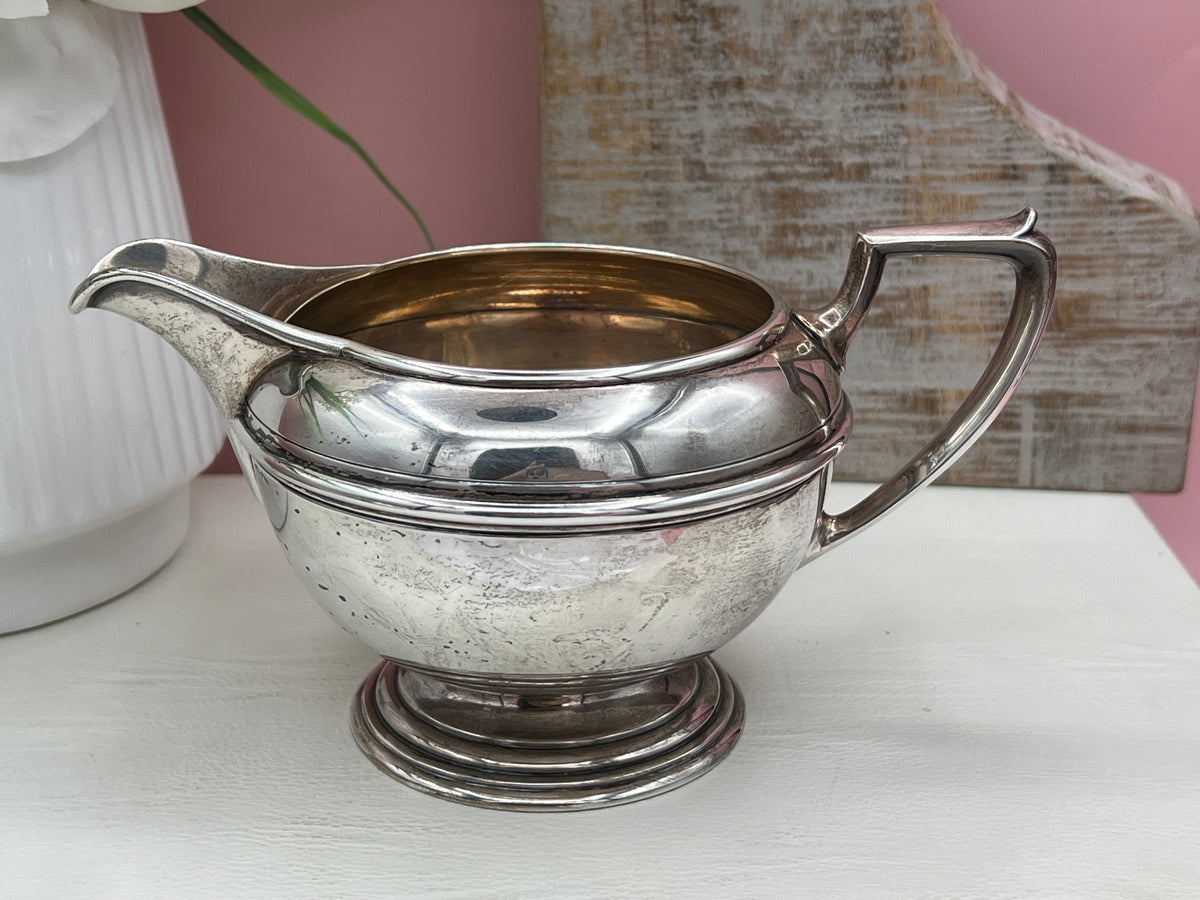 Antique William B. Durgin sterling silver two-handled covered sugar bowl with a polished urn-shaped body, stepped pedestal base, and matching domed lid topped with an urn finial displayed on a white tabletop. - Photo 6