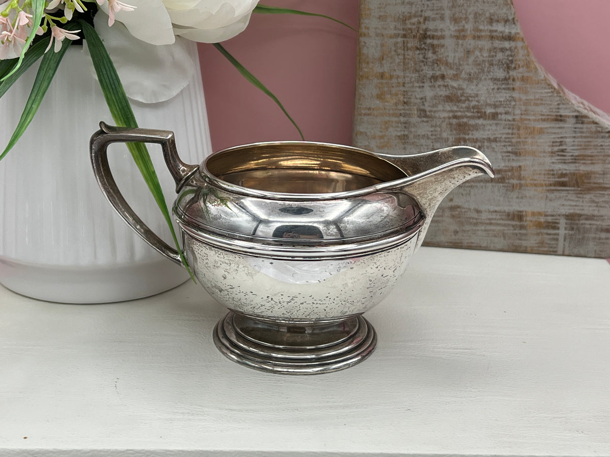 Antique William B. Durgin sterling silver two-handled covered sugar bowl with a polished urn-shaped body, stepped pedestal base, and matching domed lid topped with an urn finial displayed on a white tabletop. - Photo 7