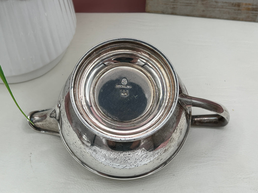 Antique William B. Durgin sterling silver two-handled covered sugar bowl with a polished urn-shaped body, stepped pedestal base, and matching domed lid topped with an urn finial displayed on a white tabletop. - Photo 9